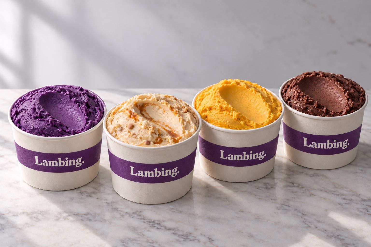 Four Lambing cups of ube, pili caramel, mango and cacao ice cream on marble